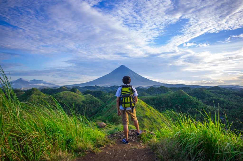 Man with a backpack in front of a mountain